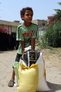 A Yemeni boy receives food aid