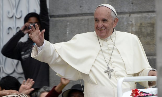 Pope Francis waves as he rides in the popemobile through the Ecuadorean capital, Quito.