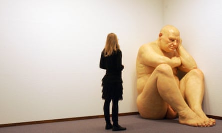A woman contemplates the sculpture "Untitled (Big Man)" by Australian artist Ron Mueck 16 February 2006 at the Neue Nationalgalerie museum in Berlin