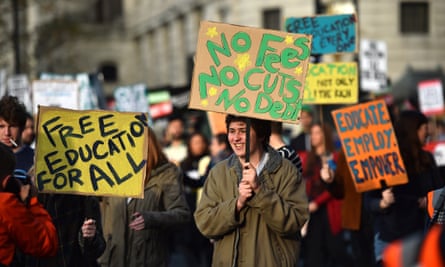 Students hold signs as they march in London against university fees on November 19, 2014.