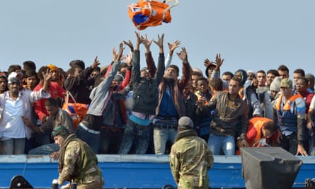 Royal Marines with migrants rescued off the Libyan coast in June.
