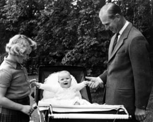 Prince Philip and Princess Anne holding Prince Andrew’s hands as he sits up in his pram, 7 September 1960.