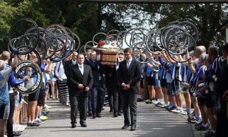 Cyclists raise bike wheels for coffin
