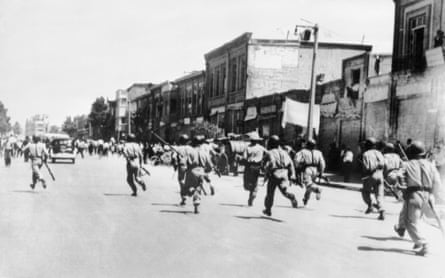 Iranian soldiers chase rioters during civil unrest in Tehran in August 1953.