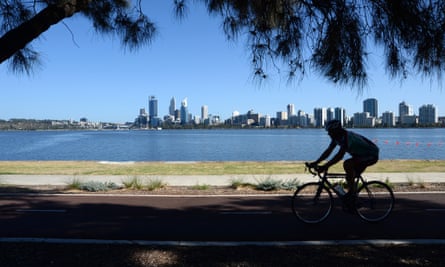 A cyclist rides along the Swan River in Perth, Australia.