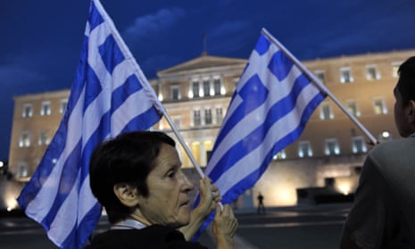 A protester holds a greek flag in front of the Greek parliament during an anti-austerity demonstration in Athens.