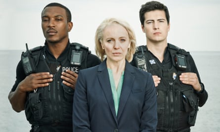 Amanda Abbington, in plain clothes playing a detective with a uniformed police officer either side of her, in the upcoming Cuffs.