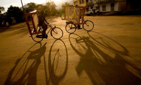 Two cyclists carrying furniture on their bicycles, in western Uganda.