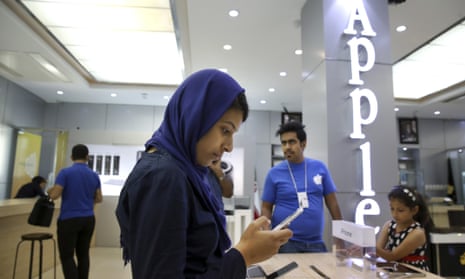 An Iranian woman tries out an iPhone in an electronics shop selling Apple products in Tehran, Iran.