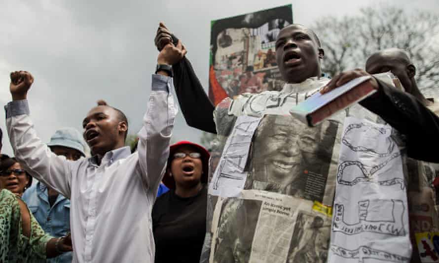 A man celebrates Nelson Mandela's life as people dance and sing outside the house of the late South African president in Johannesburg.