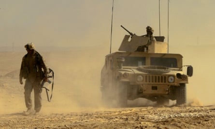 A US marine leads a Humvee as he looks for IEDs on a road near the town of al-Qaim, western Iraq, in October 2005.