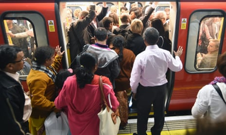 Commuters struggle to board a tube train at Westminster