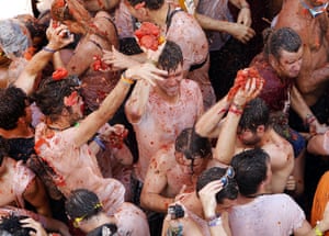 Crowds of people throw tomatoes at each other during La Tomatina in the village of Buñol, 50km outside Valencia, Spain