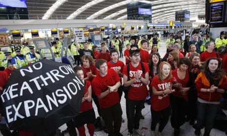 Climate change protesters chant during a demonstration inside Terminal 5 at Heathrow Airport.