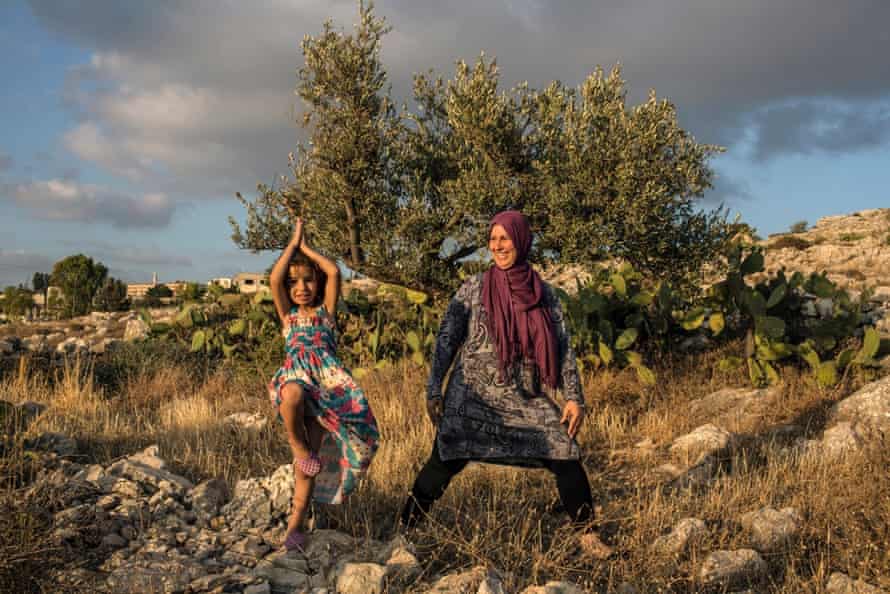 A mother and her daughter practice yoga in Palestine