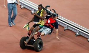 Usain Bolt gets cleaned out by a cameraman on a segway moments after successfully defending his 200m title.