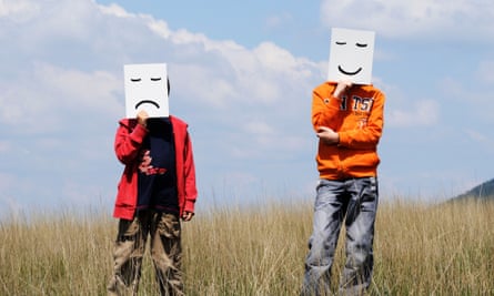 Boys in Field holding Drawn Facial Expressions