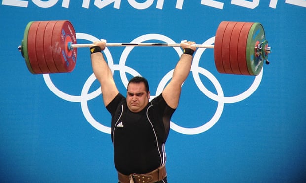 Weight lifter holds large weight above head