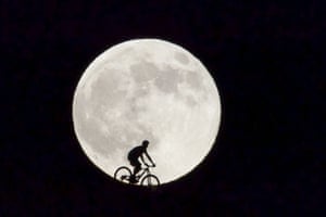 A cyclist passes the supermoon in Fuerteventura, Canary Islands