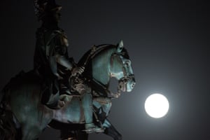 A supermoon rises behind the statue of Portuguese king Jose I in Lisbon’s Comercio Square