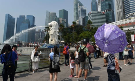 Tourists visit the Merlion statue in Singapore. The country has lifted its two-decade-long ban on visitors with HIV.