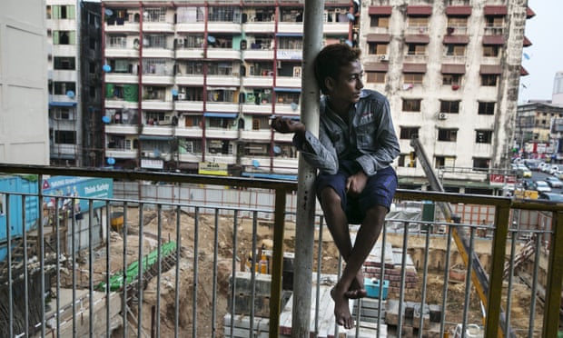 A Burmese man sits near a construction site in Rangoon. The new regulation means the minimum monthly pay for workers would be about $67, based on a six-day week.