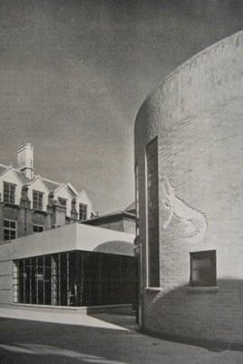 Black and white photograph of the historic Mond laboratory. The lab, to the right of the photo, is curved, with a carving of a crocodile.  A single storey square building is to the left, with a wraparound window covering most of the visible walls.