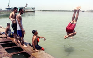 Iraqis swim near Basra port to cool themselves in Basra city, north of Iraq.