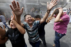 Workers from the Greater Amman Municipality spray children with a water sprinkler to cool them down in Amman, Jordan.