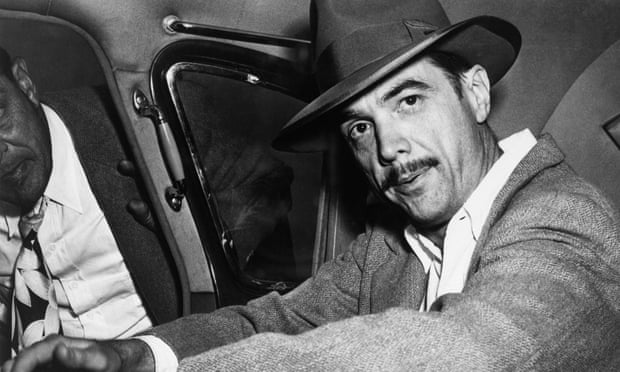 Howard Hughes seated in an automobile.