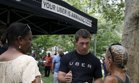 An Uber representative speaks to people during the kick off of a citywide jobs tour in the Queens borough of New York, 2015.