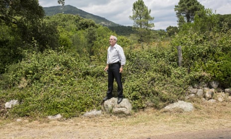 A man stands on a rock to watch the Tour de France between Porto-Vecchio and Bastia in 2013.
