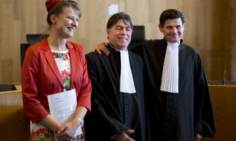 Urgenda Foundation director Marjan Minnesma, left, and lawyers Koos van der Berg, center, and Roger Cox, right, pose for pictures after a Dutch court ordered the government to cut the country's greenhouse gas emissions by at least 25% by 2020.