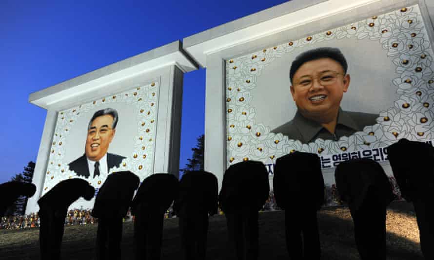Koreans pay their respects in front of two portraits, in 2012.