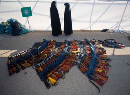 Members of the Basij militia’s Alzahra battalion stand next to assault rifles after a military parade to mark Basij week at a Revolutionary guard’s military base in northeastern Tehran November 25, 2008.