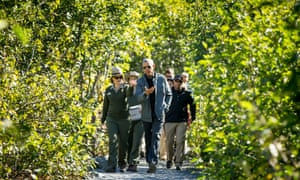 President Barack Obama speaks with a National Park Service employee as he take a hike to view the Exit Glacier in Seward, Alaska, which according to National Park Service research, has retreated approximately 1.25 miles over the past 200 years.