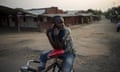A bicycle taxi-man listens to the news using the radio on his mobile phone while waiting for clients in Bujumbura, Burundi.