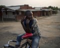 A bicycle taxi-man listens to the news using the radio on his mobile phone while waiting for clients in Bujumbura, Burundi.