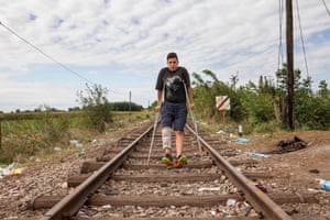 Hassan Hassanein, 14, makes his way on crutches as he crosses into Hungary from Serbia on an abandoned railway line.