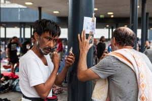 Two men shaving at the Budapest Railway station. Thousands of migrants have been camped out at the station waiting for trains to Germany.