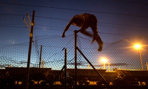 A man scales a fence in a bid to reach the Channel Tunnel at Calais.