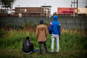 Men watch a train approach the Eurotunnel terminal in Coquelles near Calais.