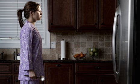 woman in pyjamas looking at the fridge