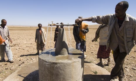 A man turns on a water tap in the dessert