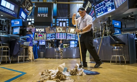 A worker cleans the floor of the New York Stock Exchange after US markets fall.