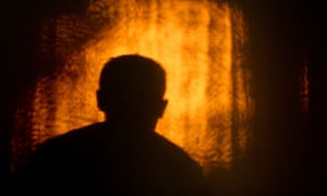 Silhouette of man's head against a patch of light on the wall