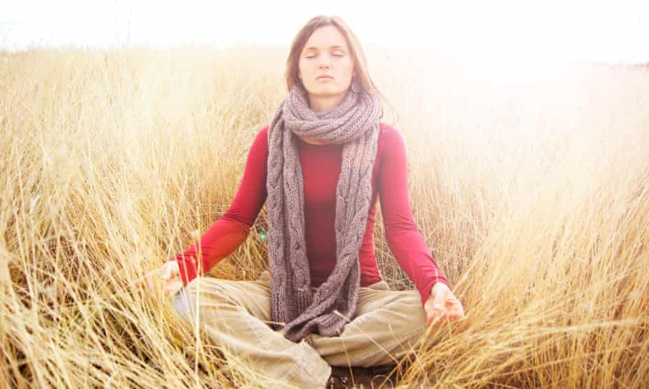 woman meditating in field