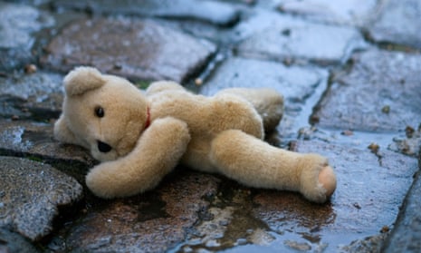 teddy bear abandoned in wet street