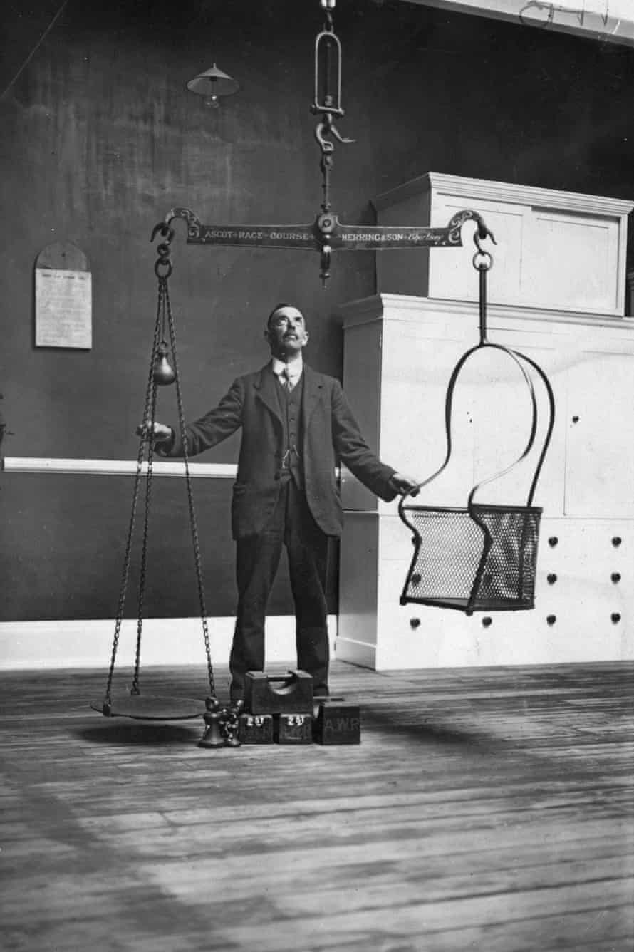 16th June 1924: A horse racing official testing the scales in the jockey-weighing room in preparation for Royal Ascot.