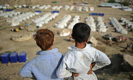 Two boys look out over a large relief camp run by The National Rural Support Program, and aided by Oxfam, UNHCR, Medecins Sans Frontieres, and Diakone at Charsadda on September 23, 2010.  